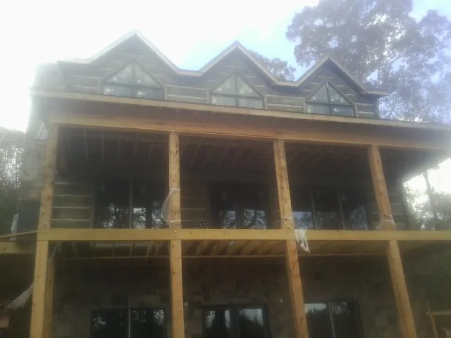 Dormers and porch framing on a large log home under construction — Roof Coating work by our crew in South Fallsburg